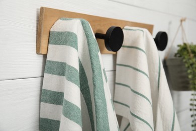 Photo of Different kitchen towels hanging on rack, closeup