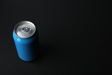Blue can of energy drink on black background. Space for text