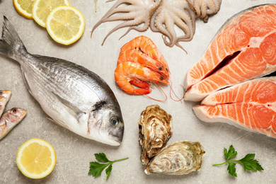 Photo of Fresh fish and seafood on light grey table, flat lay