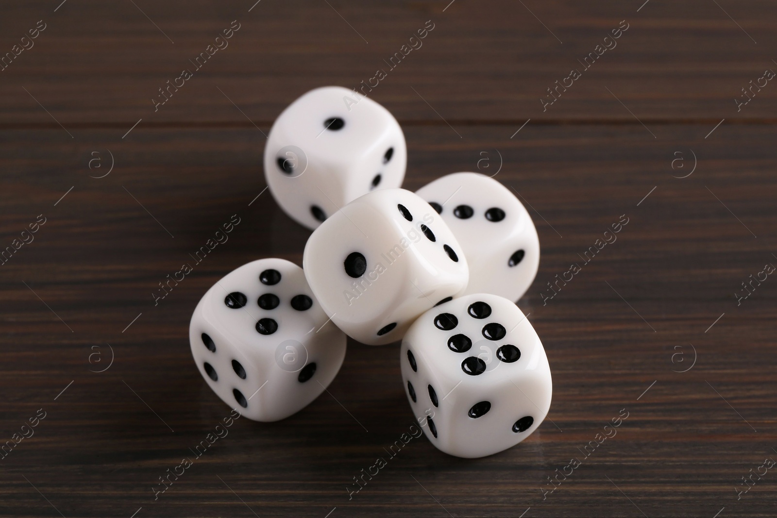 Photo of Many white game dices on wooden table, closeup