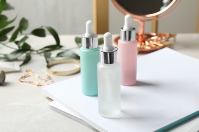 Bottles of cosmetic products on light grey table