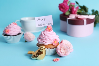 Photo of Festive surprise with tasty treat for Mother's Day on color background