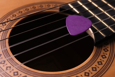 Closeup view of acoustic guitar, focus on sound hole with plectrum