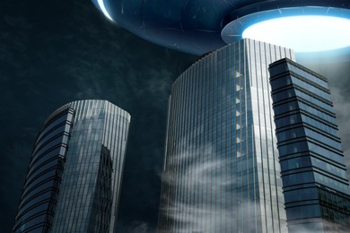 Image of Alien spaceship flying over buildings. UFO, extraterrestrial visitors