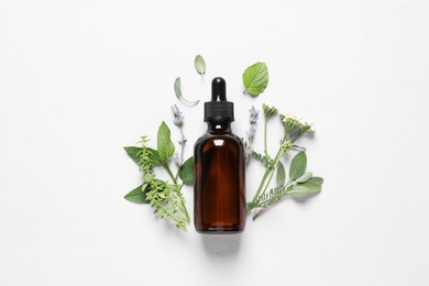 Bottle of essential oil, different herbs and flowers on white background, flat lay