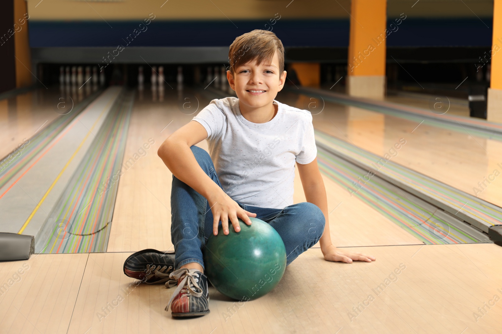 Photo of Preteen boy with ball in bowling club