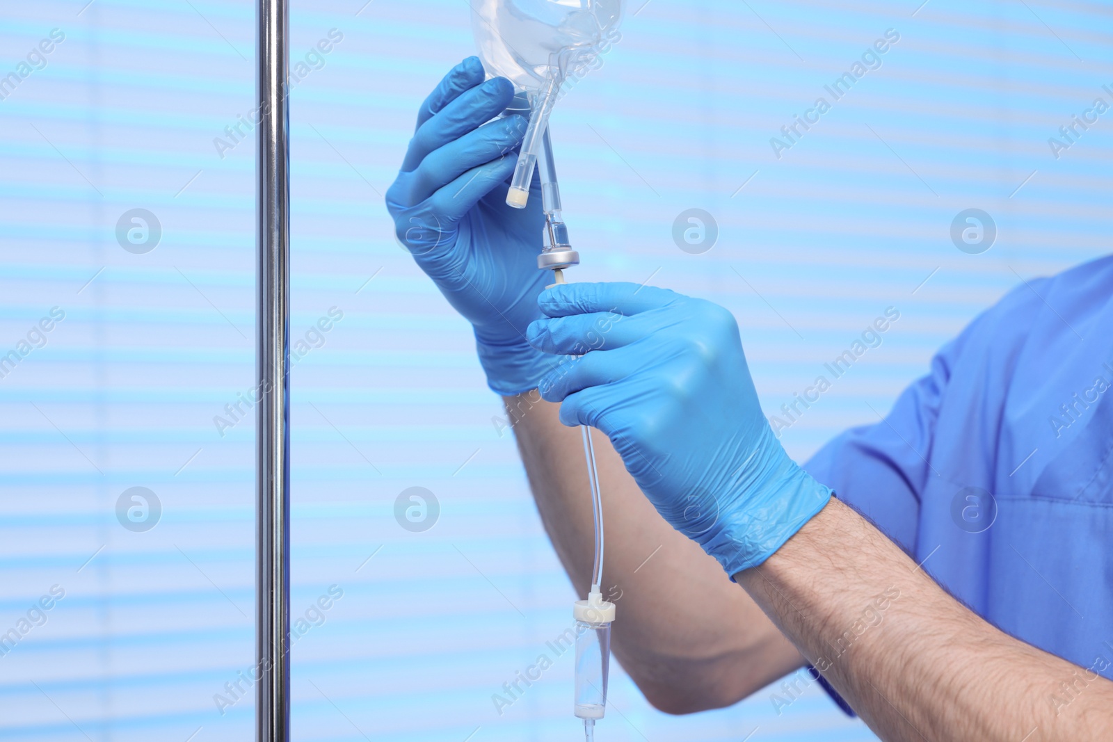 Photo of Nurse setting up IV drip in hospital, closeup
