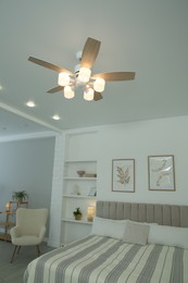 Photo of Ceiling fan, furniture and houseplants in stylish bedroom