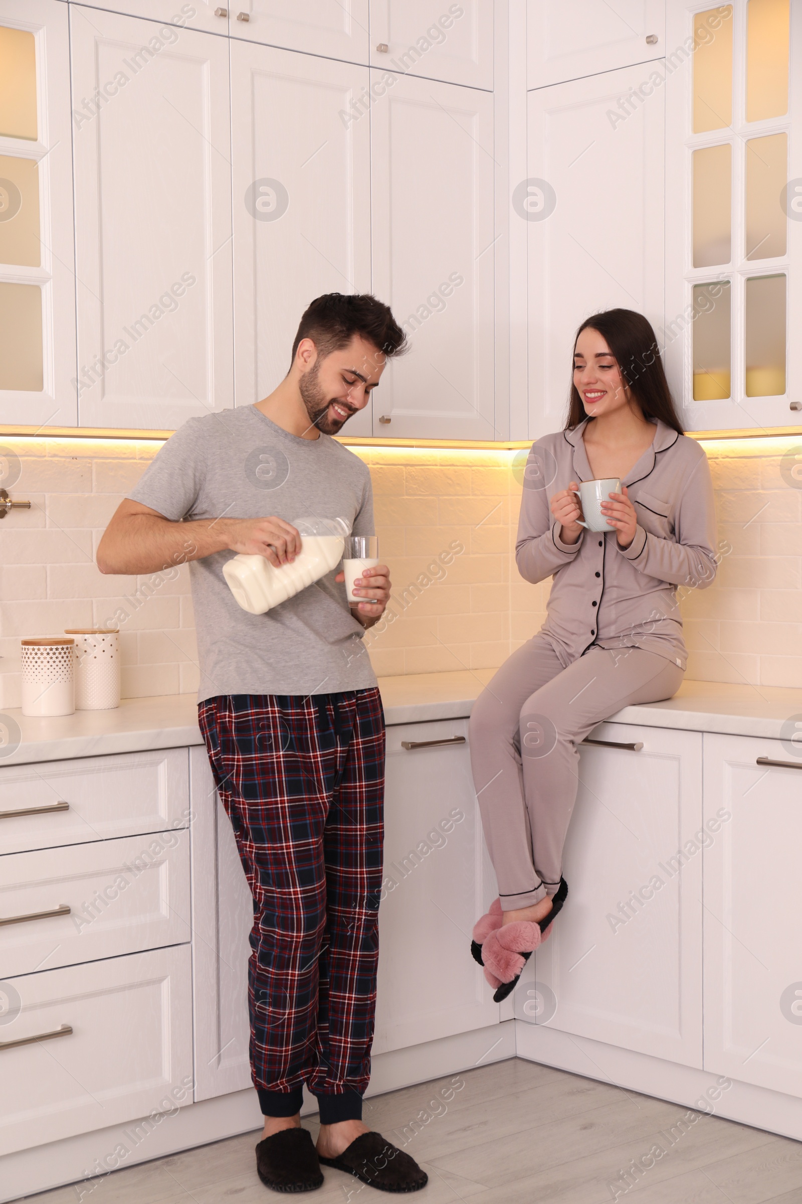 Photo of Happy couple in pajamas having breakfast at home