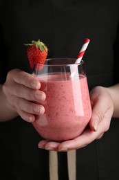 Photo of Woman holding tasty strawberry smoothie, closeup view