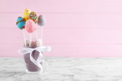 Photo of Delicious sweet cake pops on marble table, space for text. Easter holiday