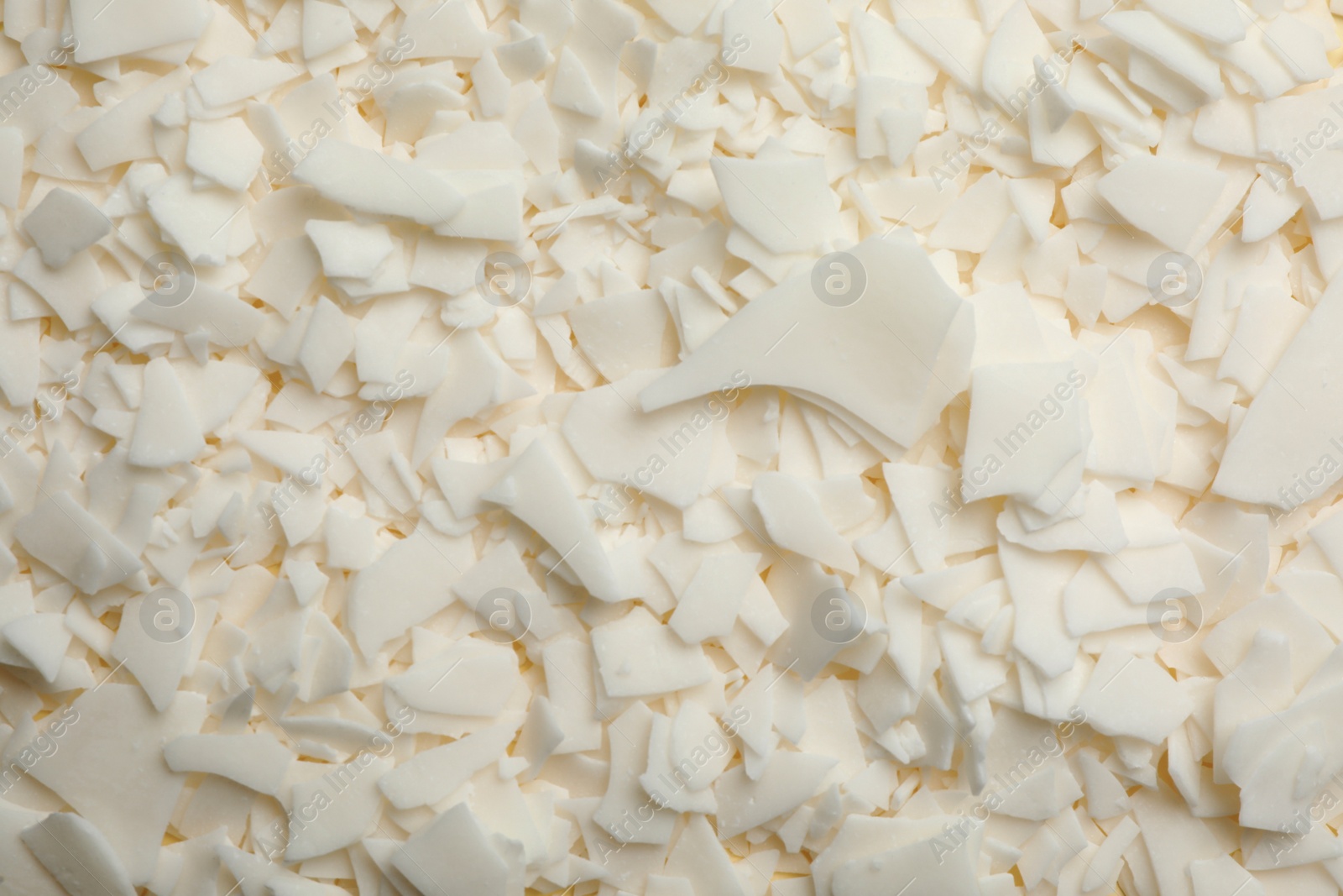 Photo of Heap of soy wax flakes as background, top view. Homemade candle material