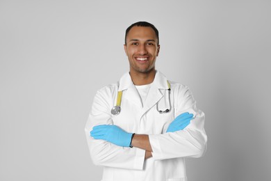 Photo of Doctor or medical assistant (male nurse) in uniform with stethoscope on light grey background