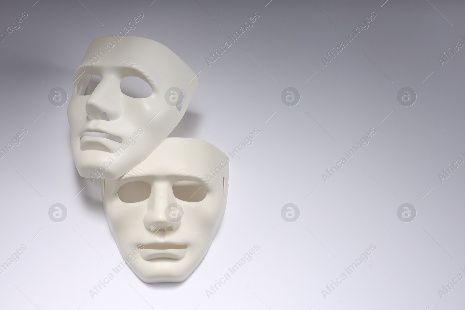 Photo of Theater arts. Two masks on white background, above view. Space for text
