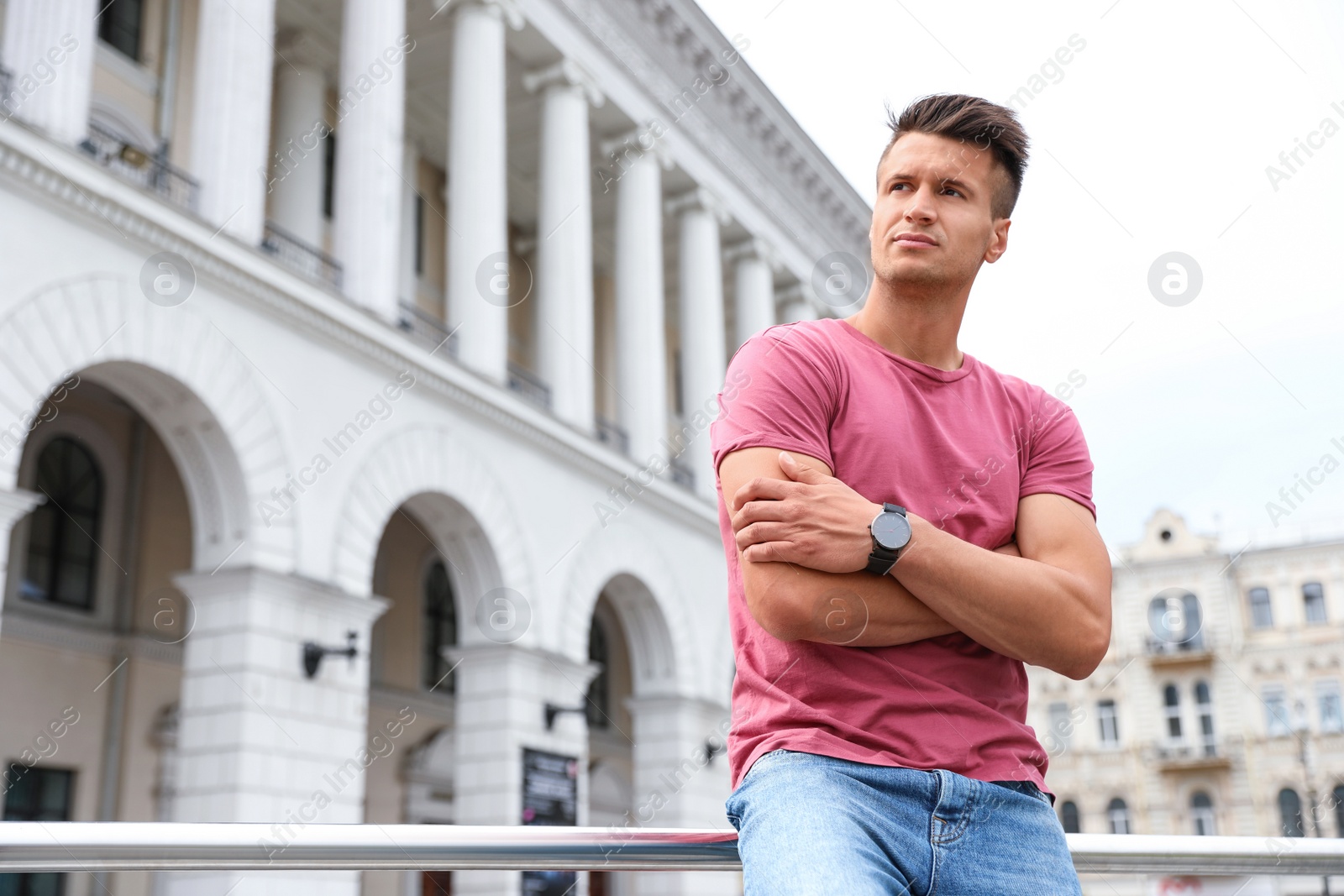 Photo of Portrait of handsome young man on city street. Space for text