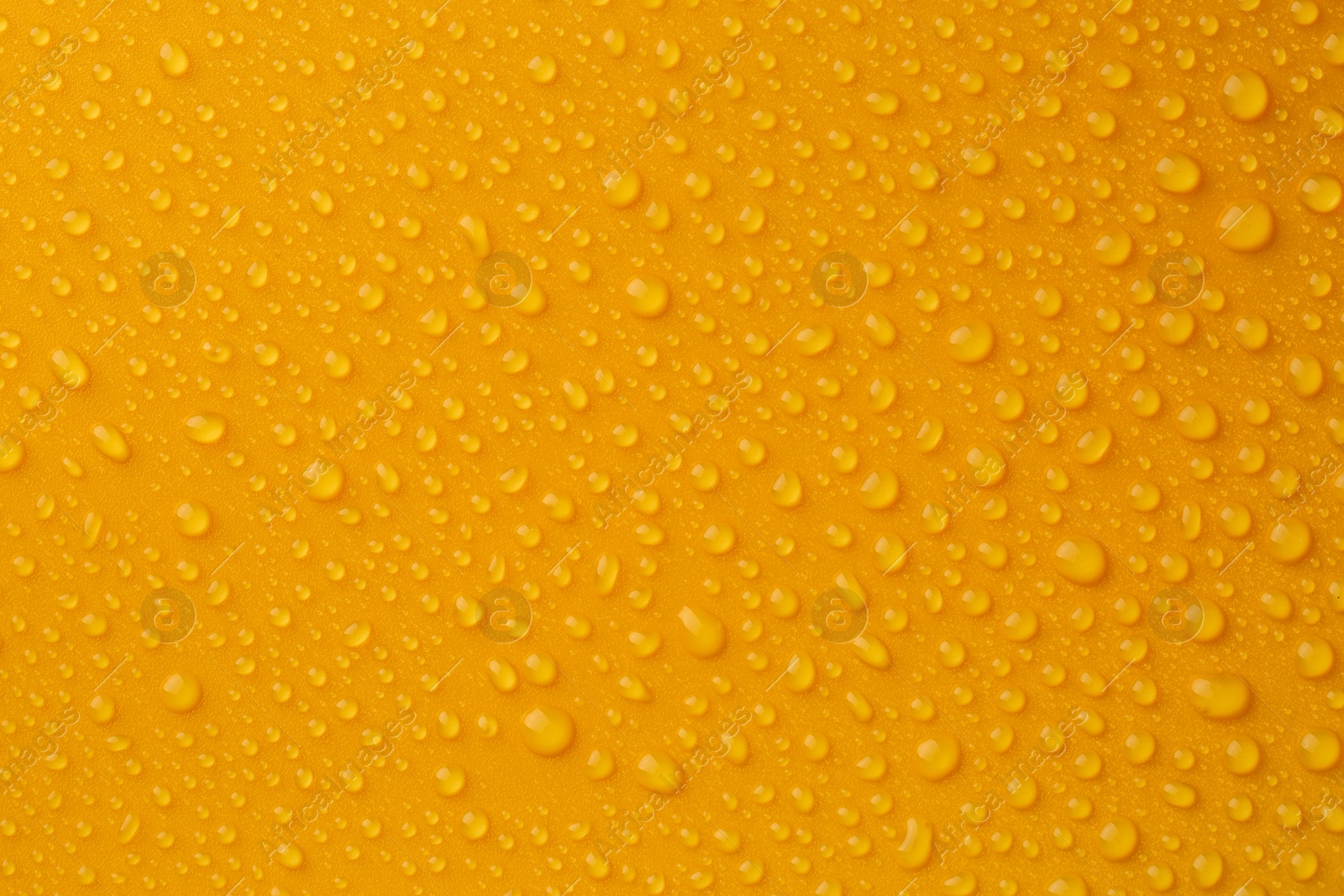 Photo of Water drops on orange background, top view