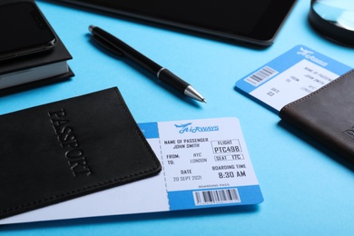 Photo of Passports with avia tickets on light blue background, closeup. Travel agency concept