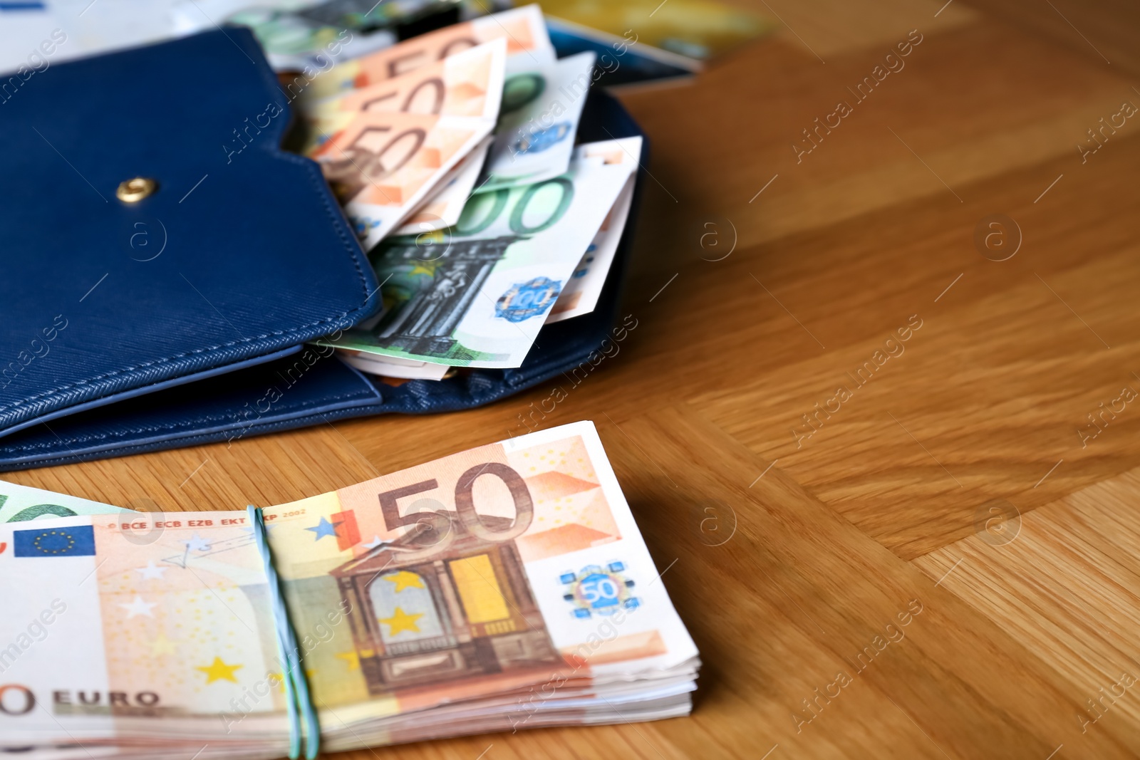 Photo of Wallet and different Euro banknotes on wooden table, closeup with space for text. Money exchange