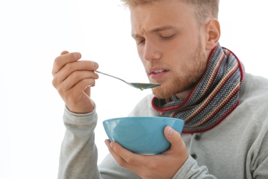 Photo of Sick young man eating soup to cure flu at home