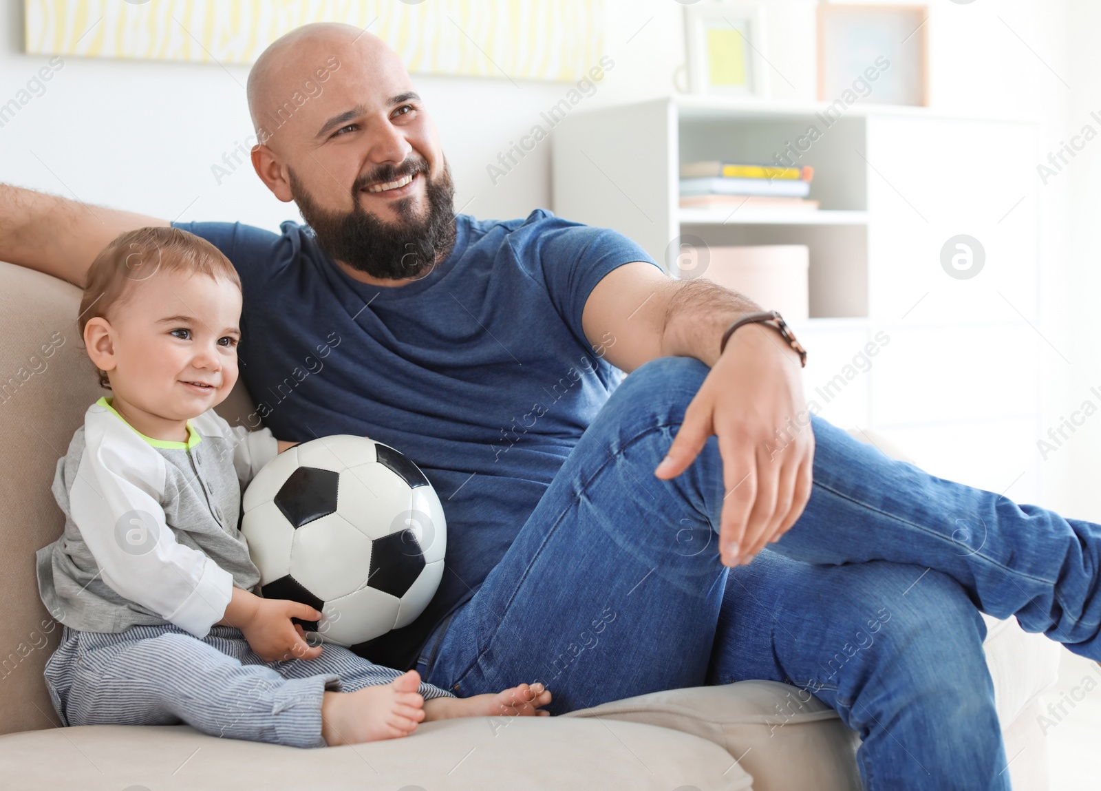 Photo of Dad and his son watching football at home