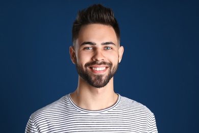 Portrait of handsome smiling man on color background