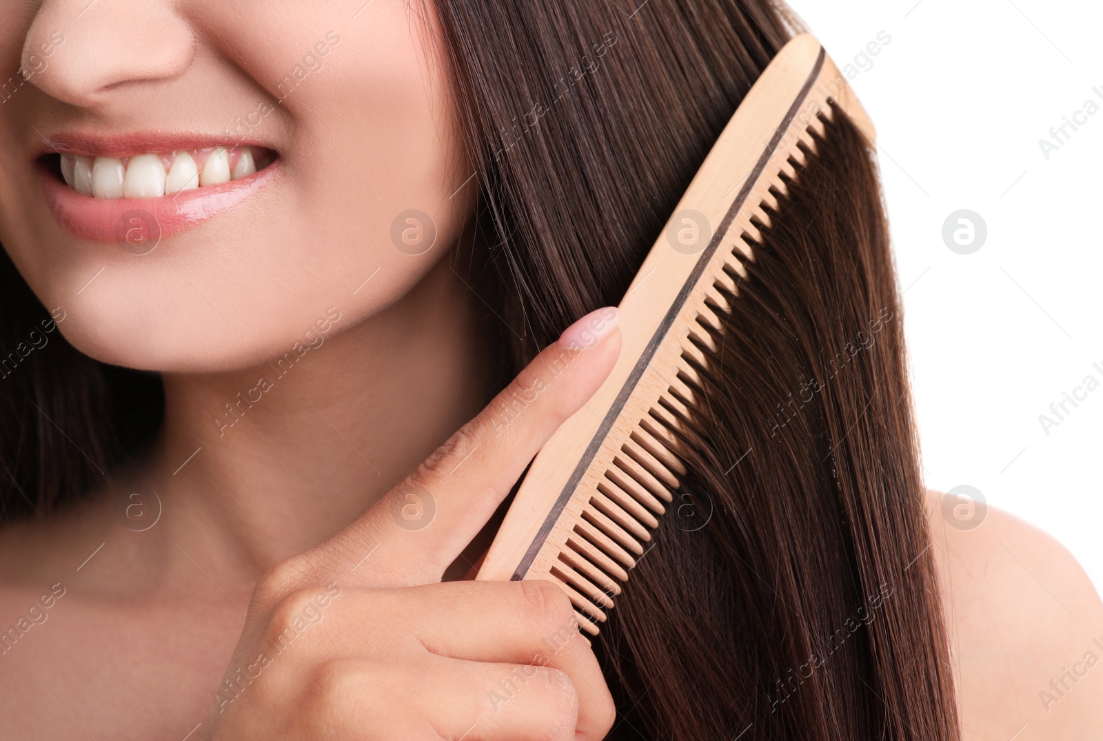 Photo of Young woman with wooden hair comb on white background, closeup