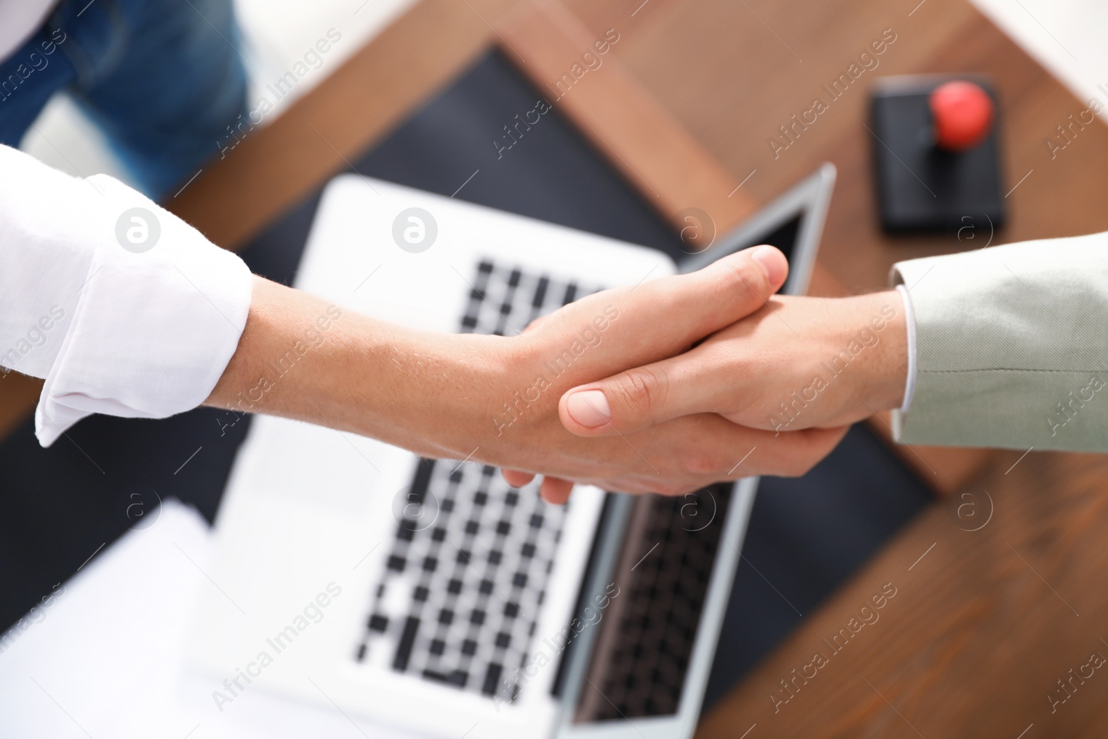 Photo of Business partners shaking hands over table after meeting, top view