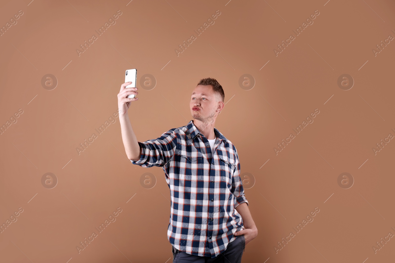 Photo of Handsome man taking selfie on color background