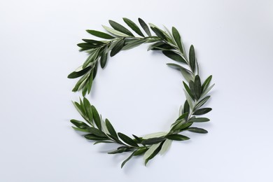 Frame made of fresh green olive leaves on white background, flat lay. Space for text