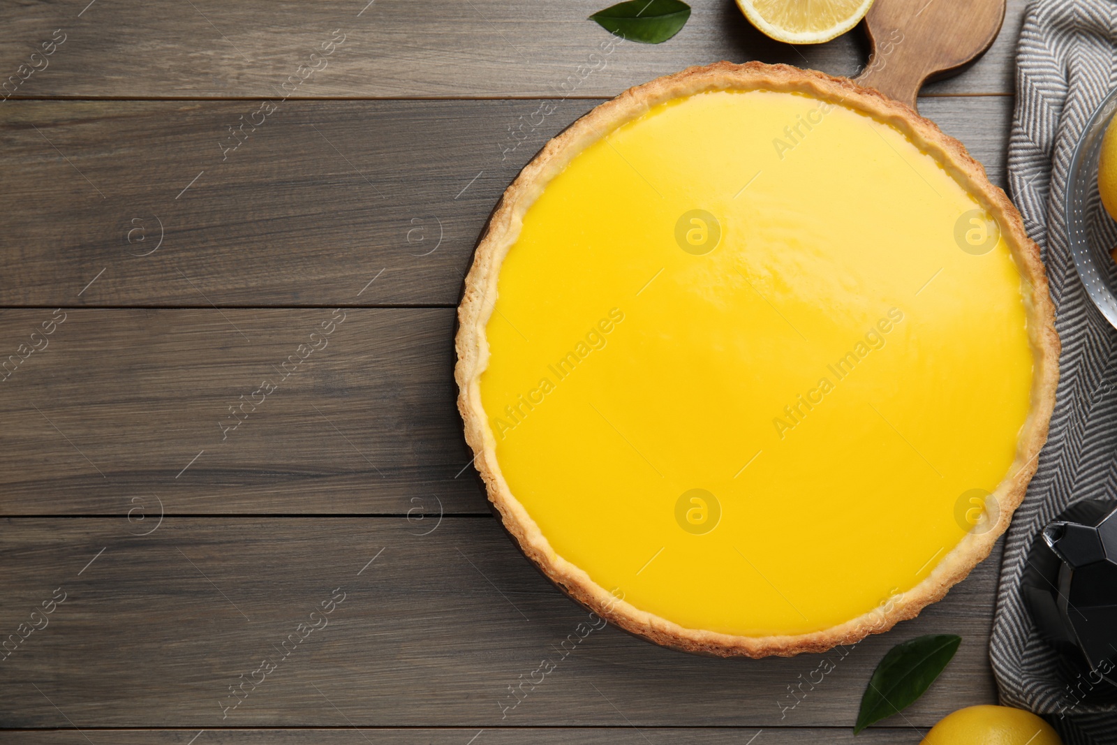 Photo of Delicious homemade lemon pie on wooden table, flat lay. Space for text