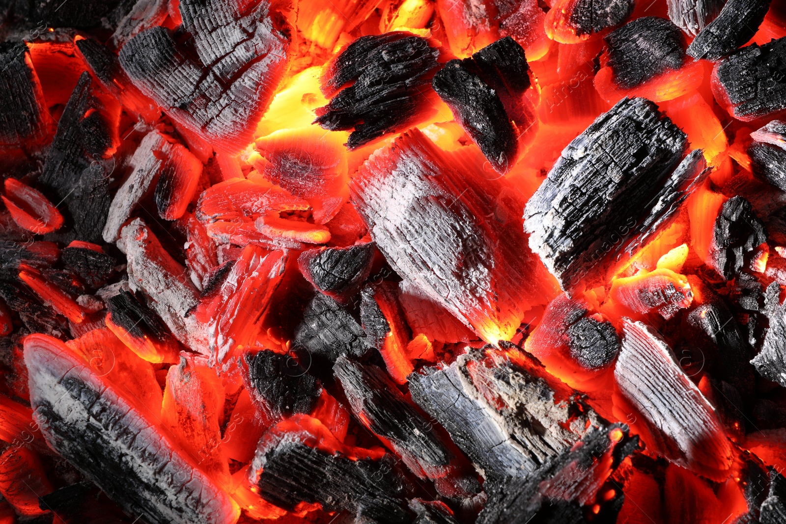 Photo of Pieces of hot smoldering coal as background, top view