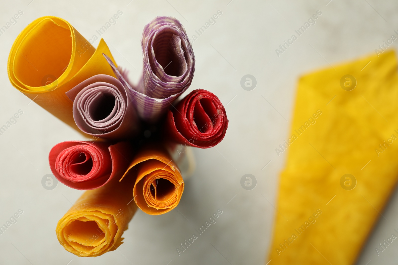 Photo of Colorful beeswax food wraps on light table, top view. Space for text