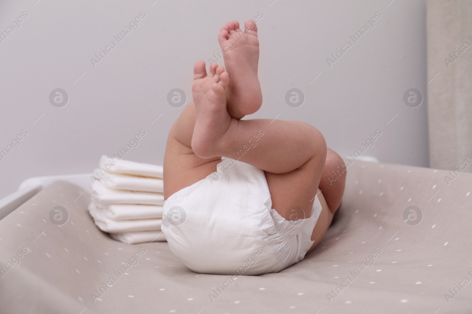 Photo of Little baby in diaper on bed, closeup