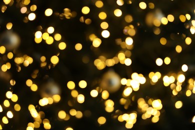 Photo of Blurred view of Christmas tree with bright fairy lights, closeup. Bokeh effect