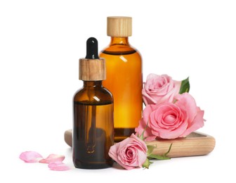 Bottles of essential rose oil and flowers on white background