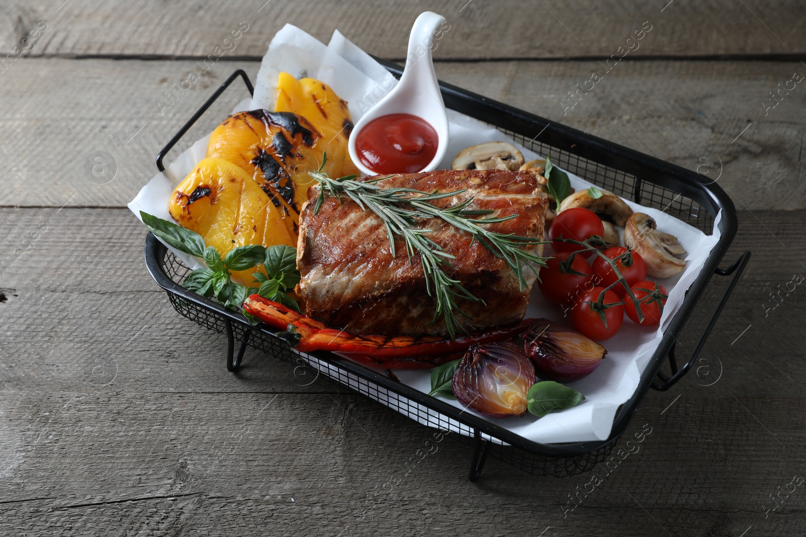 Photo of Delicious grilled meat and vegetables served with sauce on wooden table