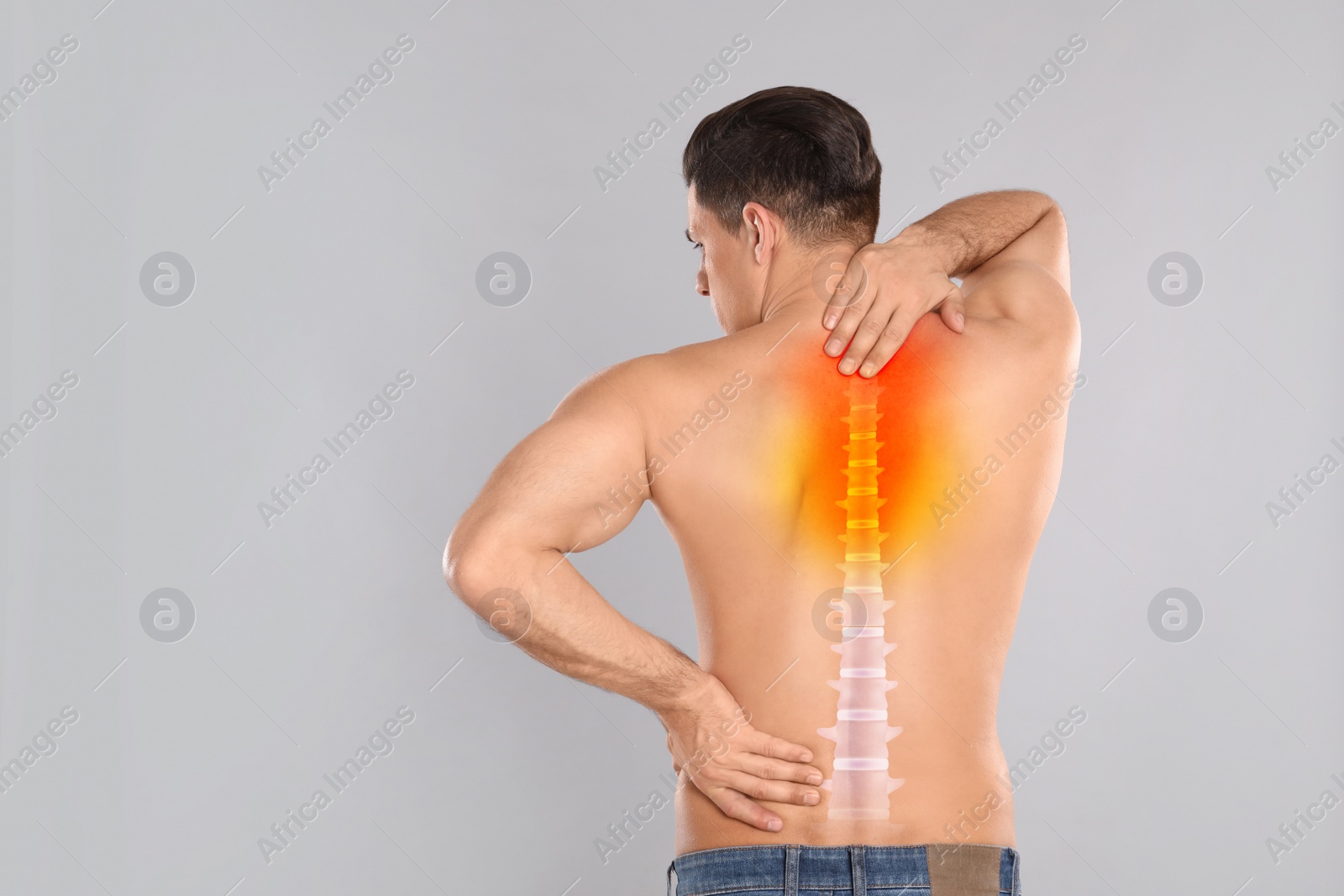 Image of Man suffering from pain in back on light grey background