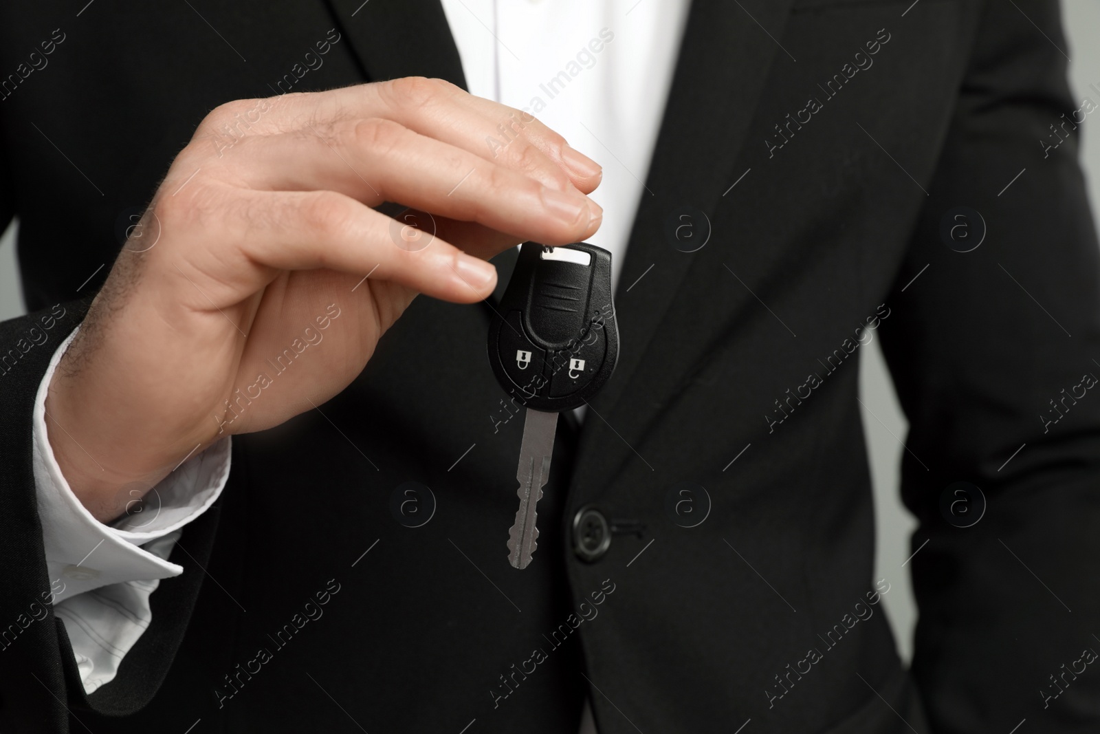 Photo of Young man holding new car key, closeup