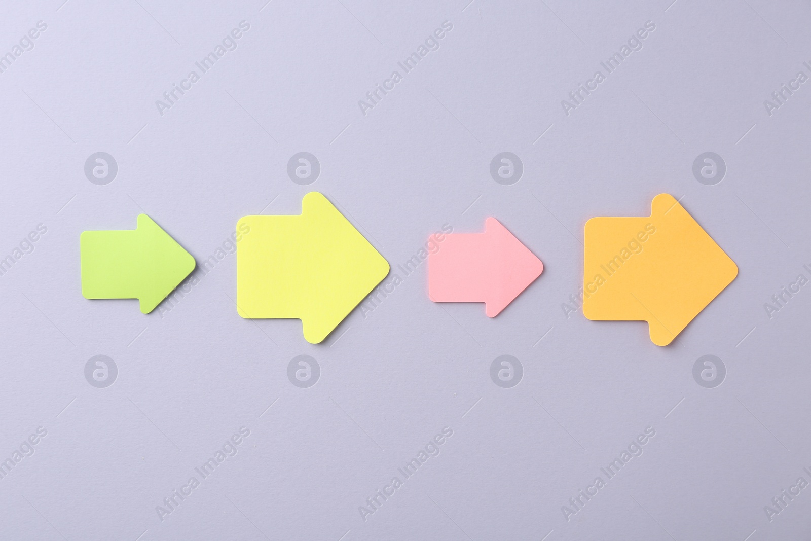 Photo of Business process organization and optimization. Scheme with arrow shaped paper notes on grey background, top view