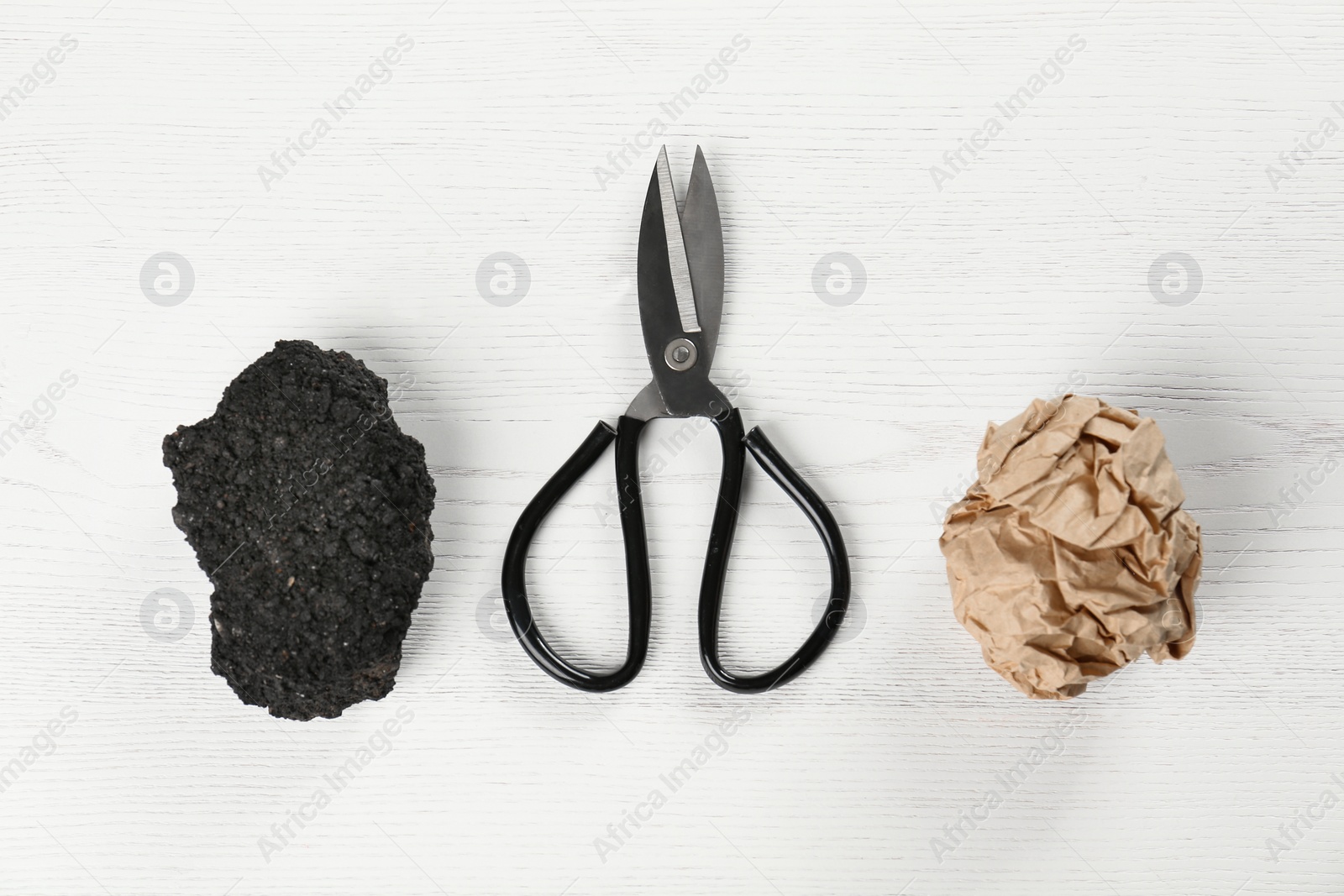 Photo of Flat lay composition with rock, paper and scissors on white wooden background