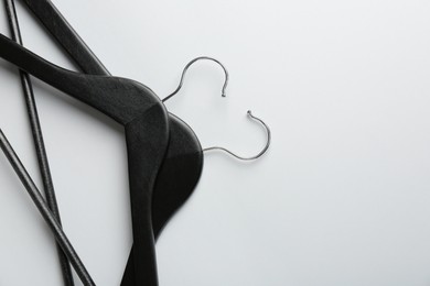 Photo of Black hangers on light gray background, top view. Space for text