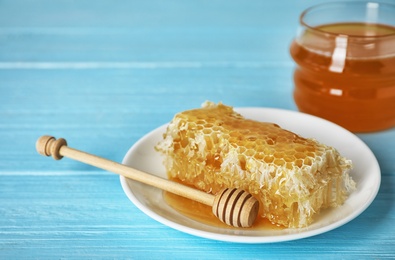 Photo of Plate with honeycomb and dipper on wooden table