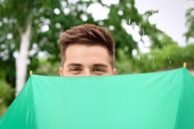 Photo of Man with umbrella outdoors on rainy day