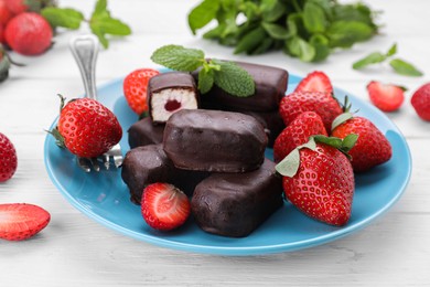 Photo of Delicious glazed curd snacks and fresh strawberries on white wooden table