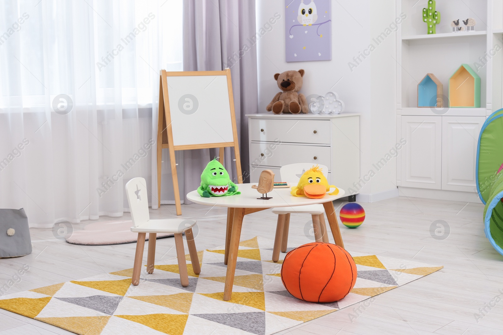 Photo of Child`s playroom with different toys and modern furniture. Stylish kindergarten interior