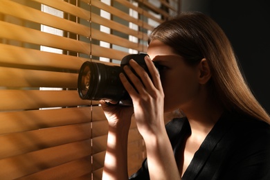 Photo of Private detective with camera spying near window indoors