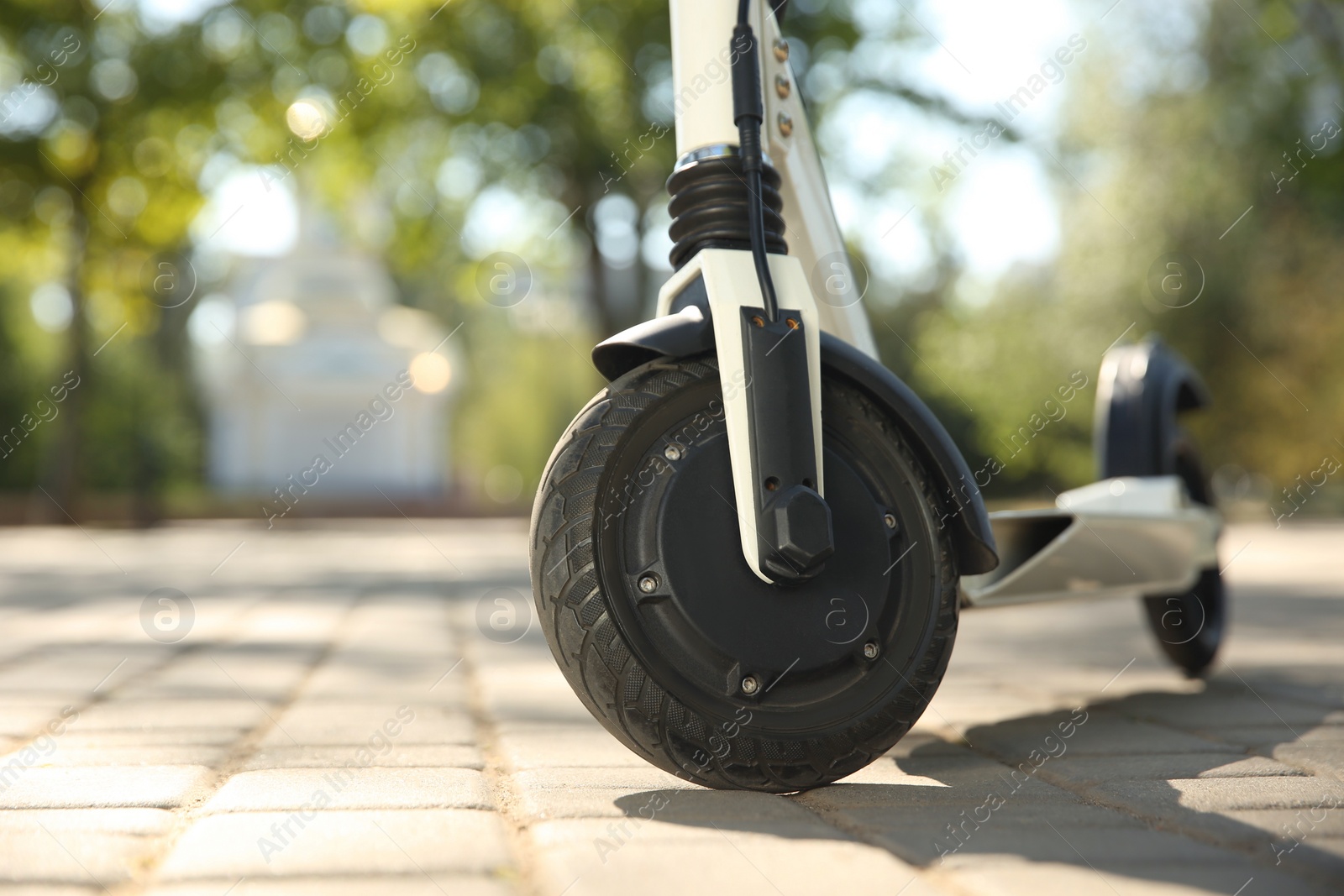 Photo of Modern electric kick scooter outdoors on sunny day, closeup. Space for text