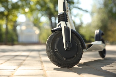 Photo of Modern electric kick scooter outdoors on sunny day, closeup. Space for text