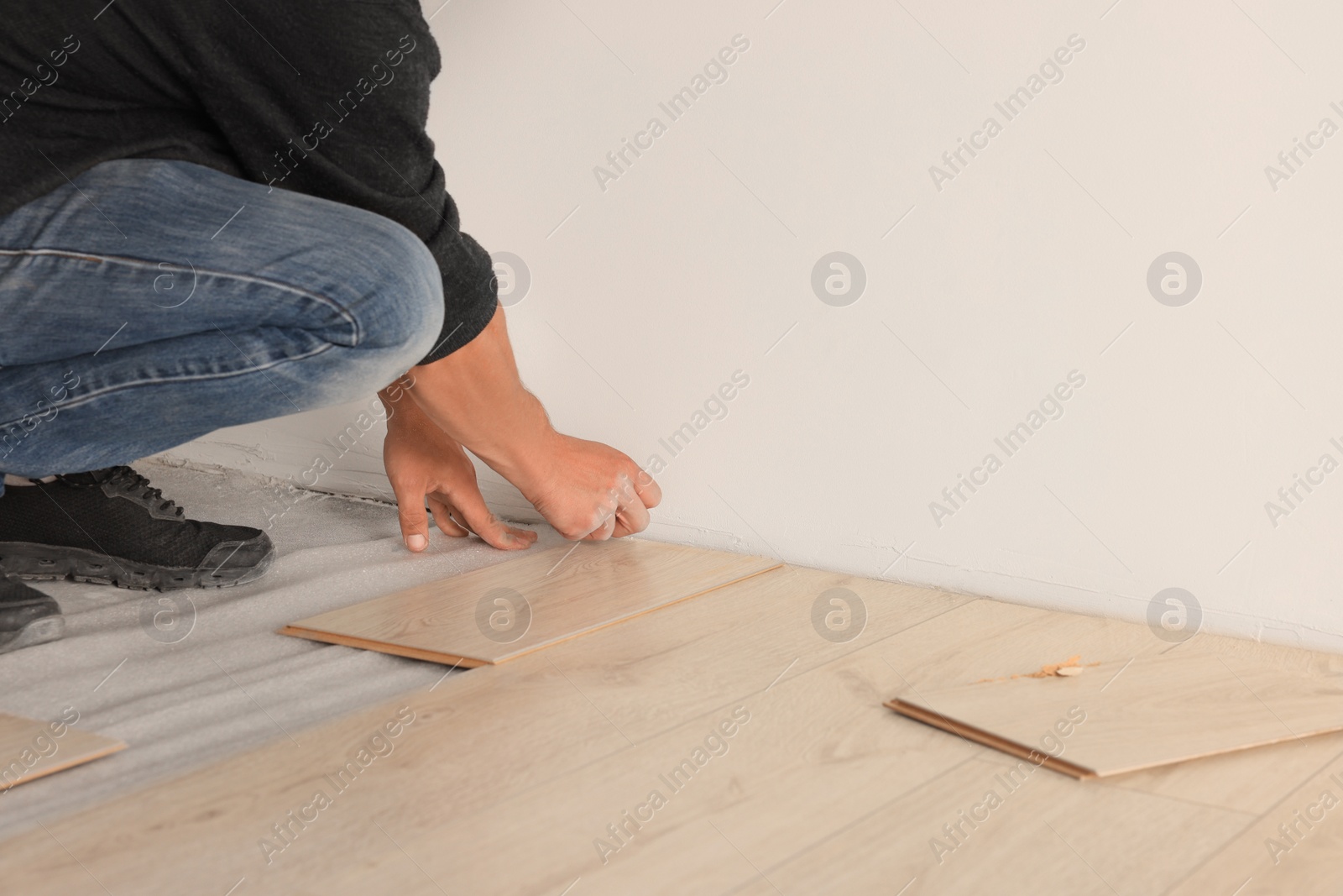 Photo of Professional worker installing new laminate flooring, closeup