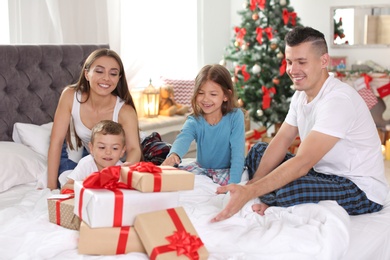 Happy parents and children with gifts celebrating Christmas at home